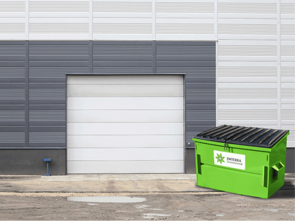Emterra Environmental Front End Bin with Black Lid Outside a Commercial Building